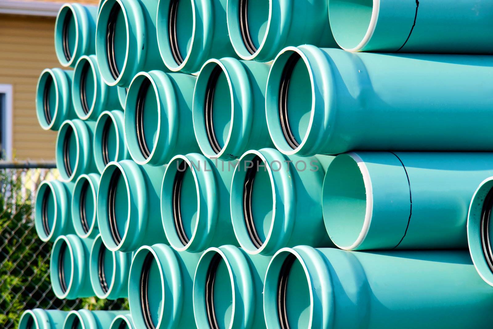 Stack of blue plastic PVC water pipe to be used in a new development of residental area