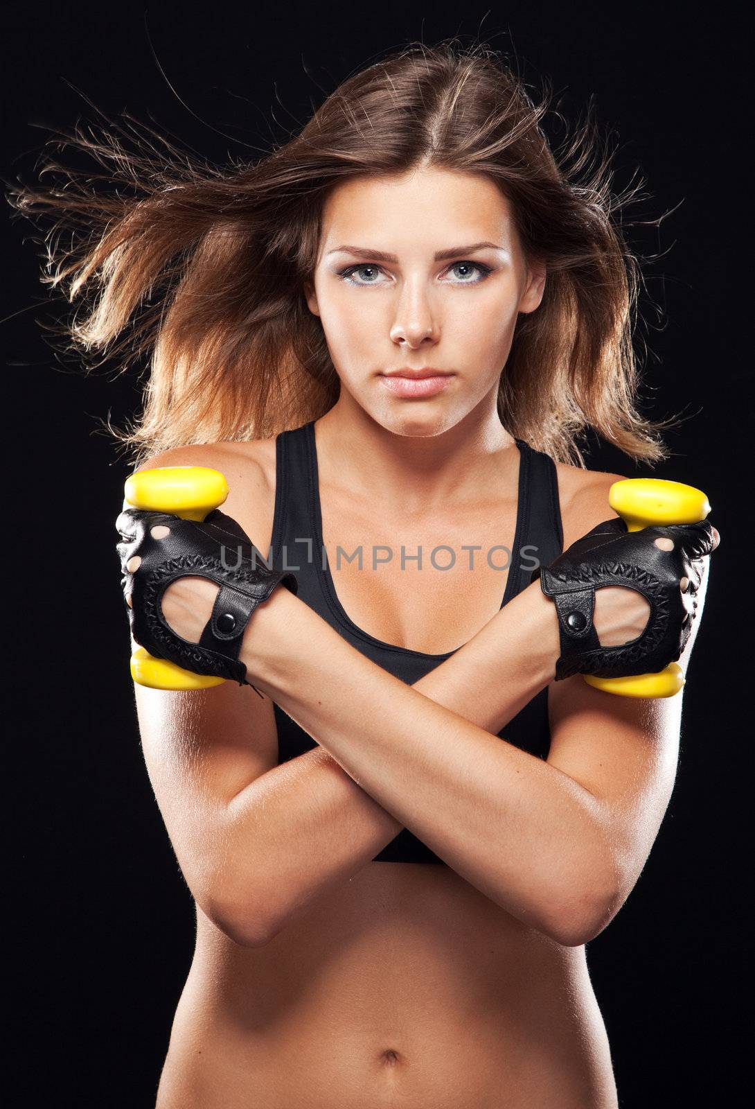Young fit woman in sports outfit, black background