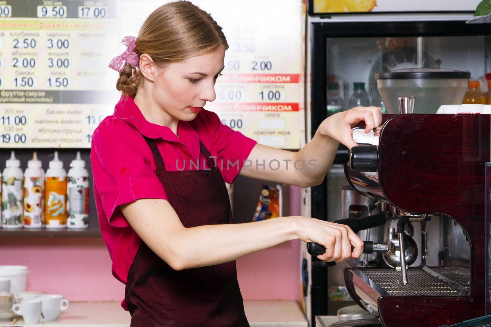 Friendly waitress making coffee at coffee machine