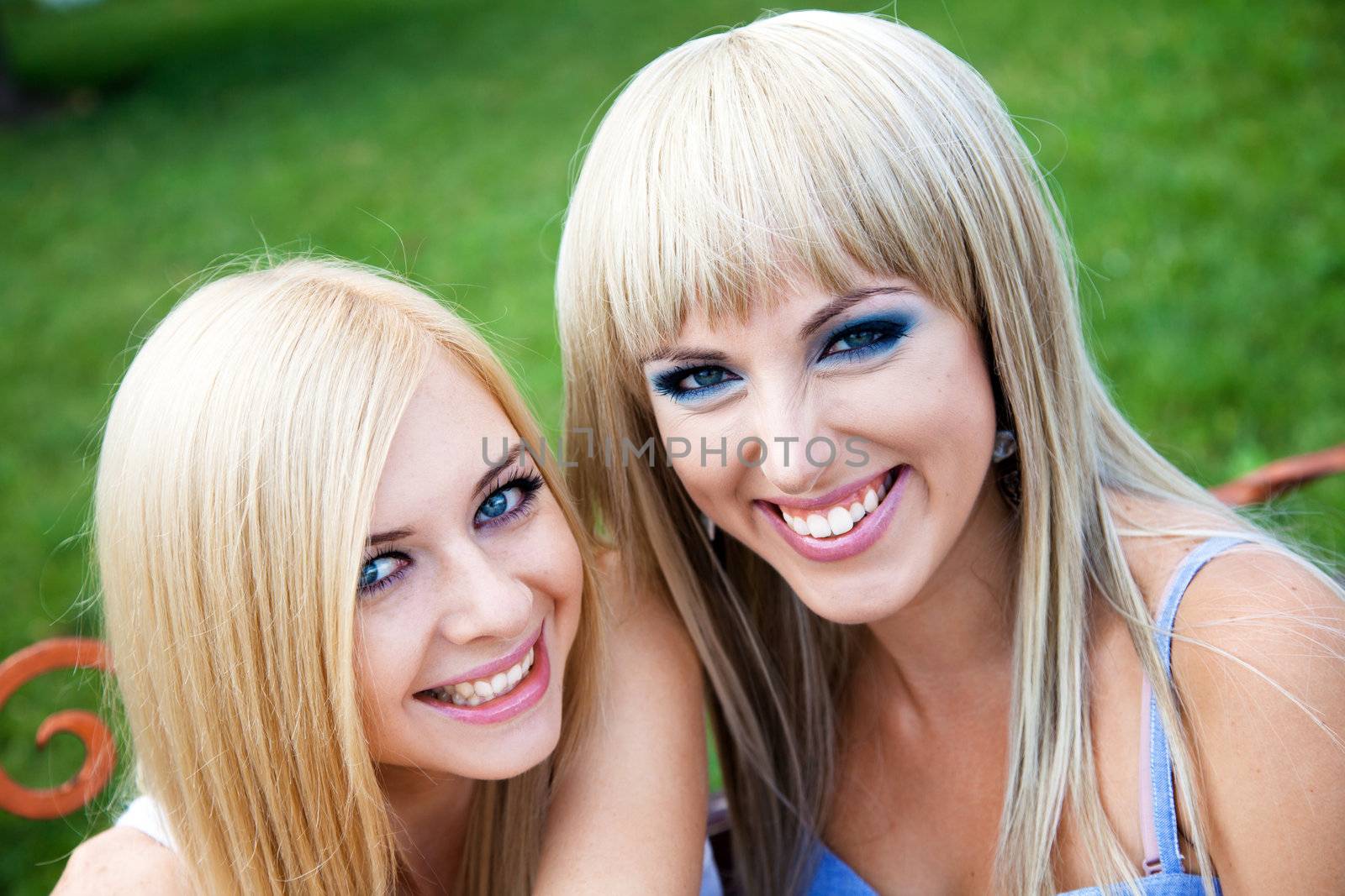 Two young pretty girl friends in a park