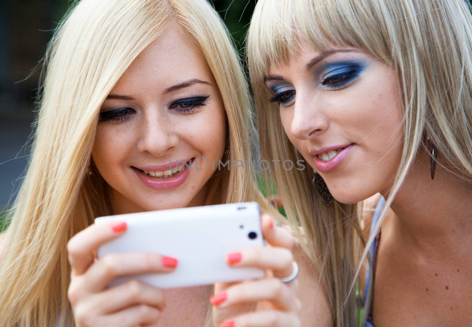 Two girl friends using a modern smartphone