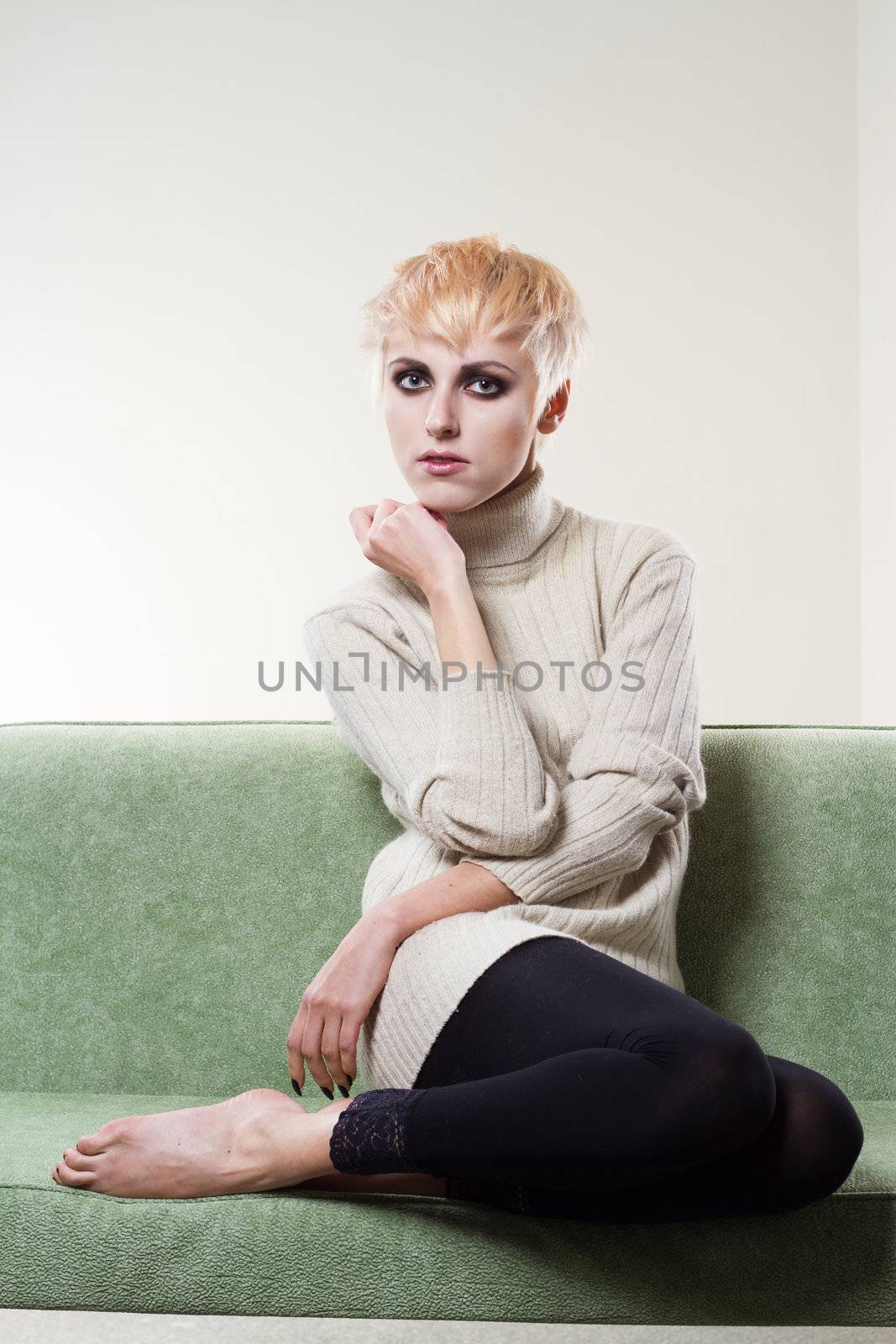 Portrait of a young beautiful woman sitting on sofa alone 