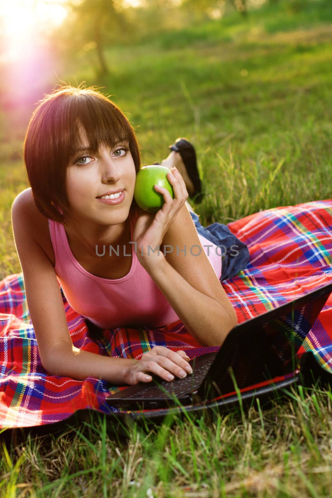 Lovely girl with laptop in the park  by Gdolgikh