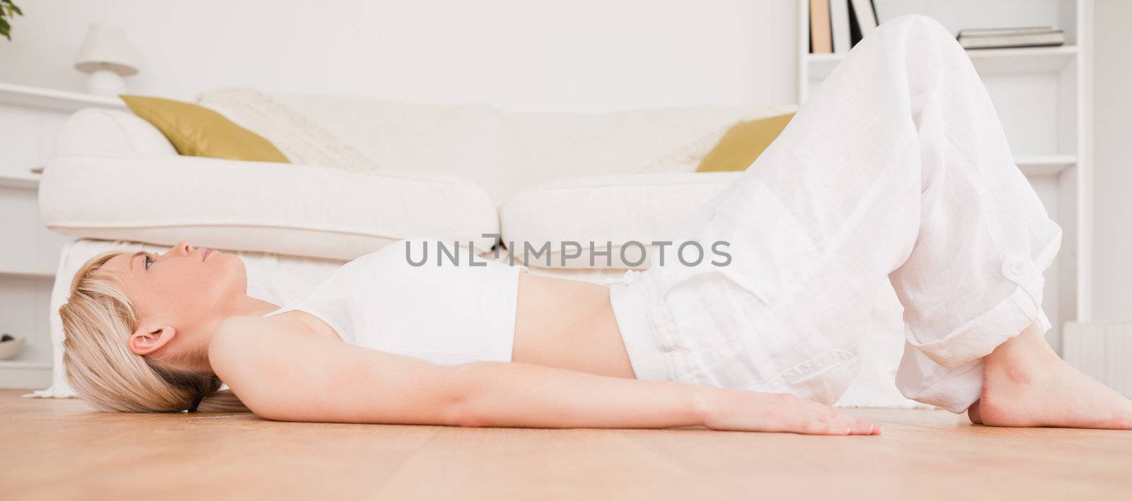 Pretty blond-haired woman doing fitness exercises in the living-room