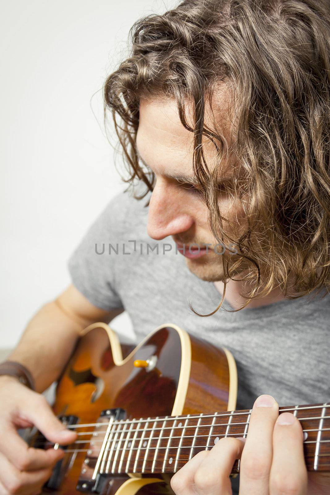 An image of a handsome man playing the guitar