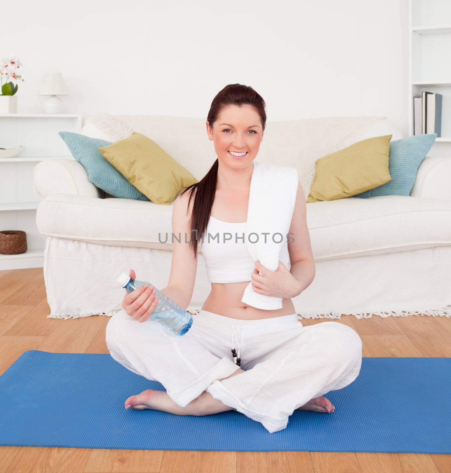 Smiling female having a rest after stretching while sitting on a by Wavebreakmedia