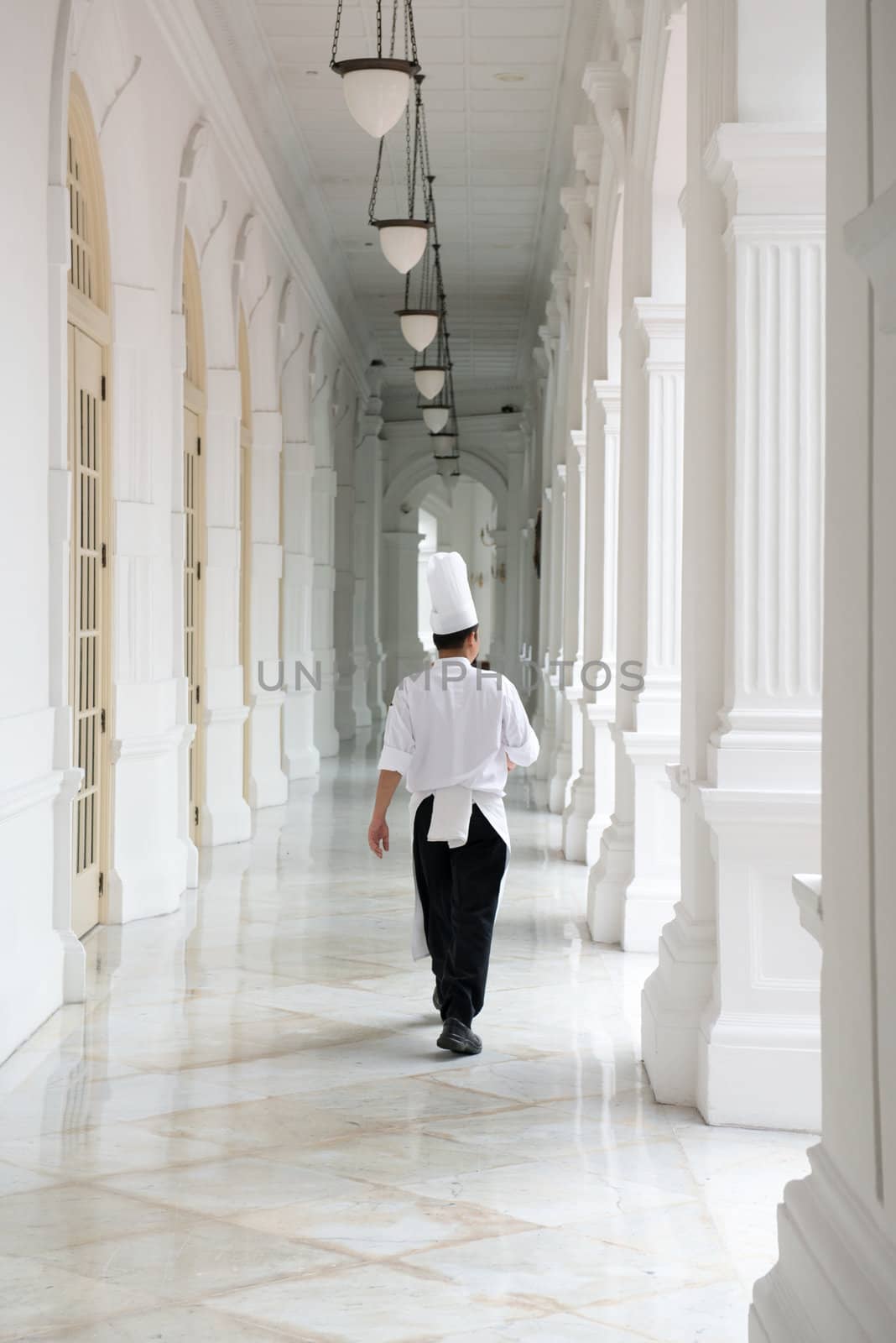 Singapore - September 08, 2012:Waiter in classical uniform in corridors of the Raffles Hotel. It is the oldest hotel in Singapore