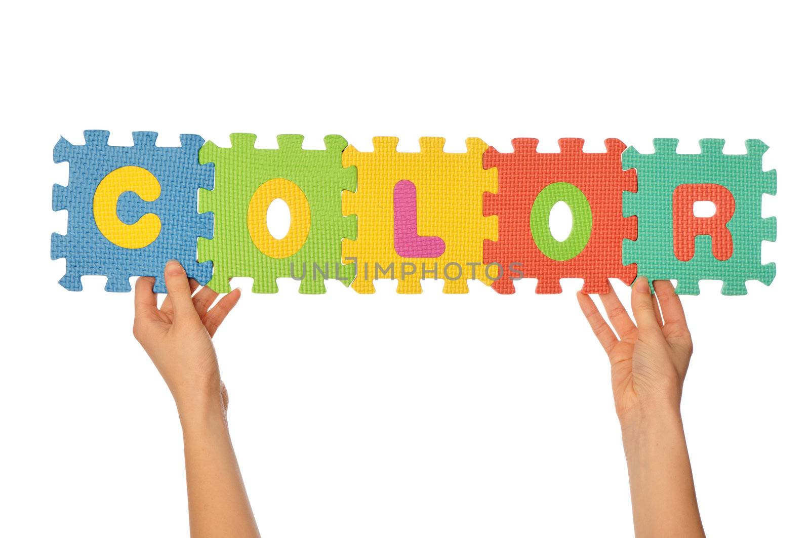 teacher holding in the hand the amusing colored educational puzzles with the word color