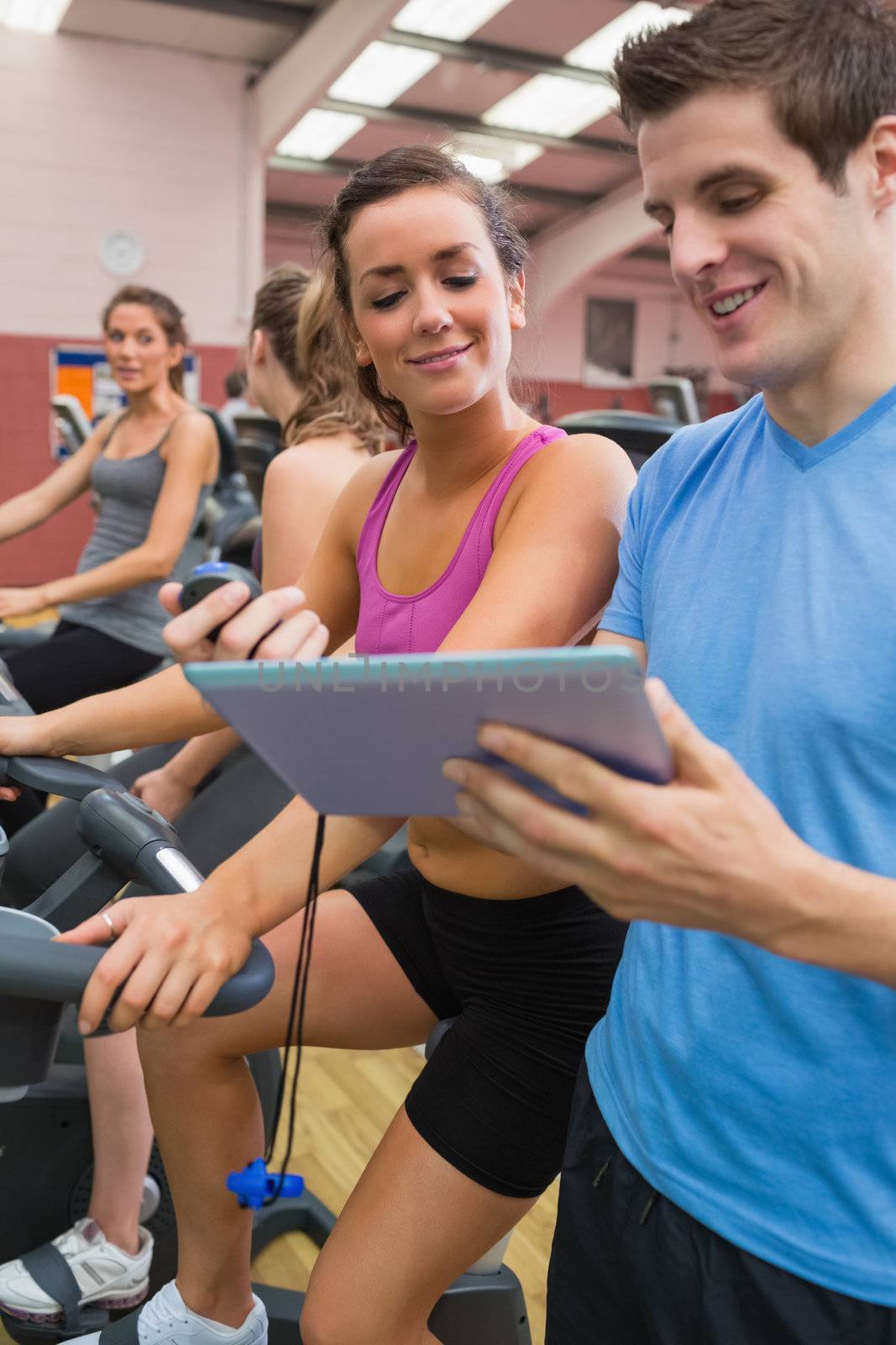People chatting in gym on exercise bicycles