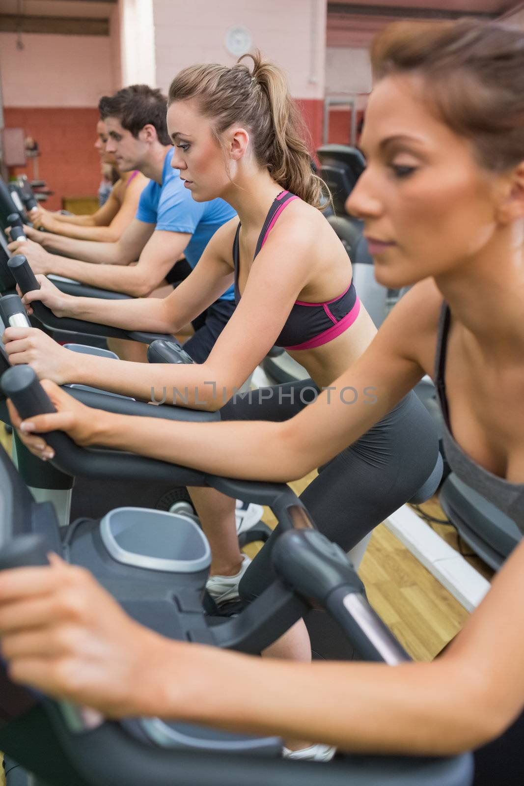 Four people on exercise bikes by Wavebreakmedia