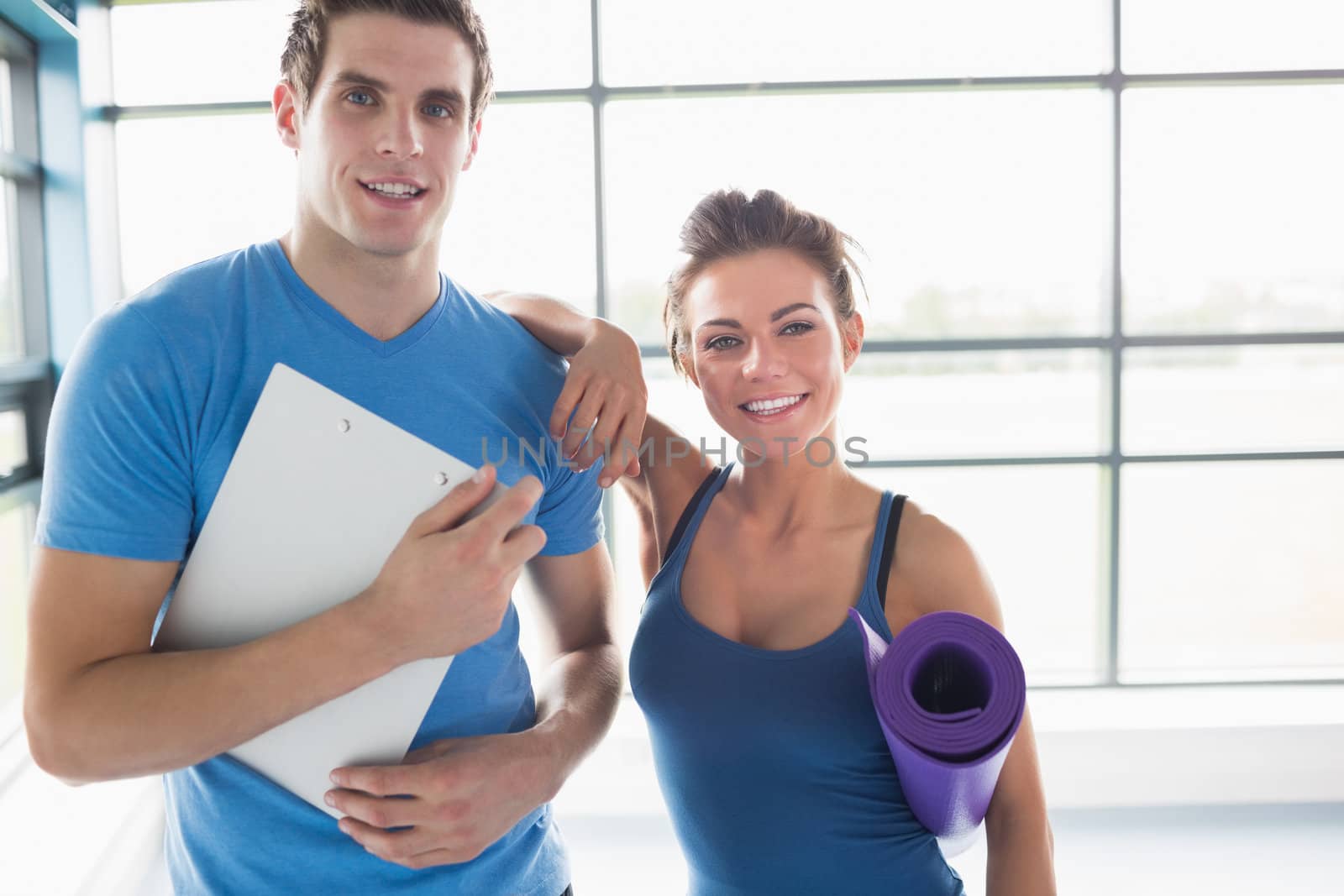 Trainer with a brunette woman in gym