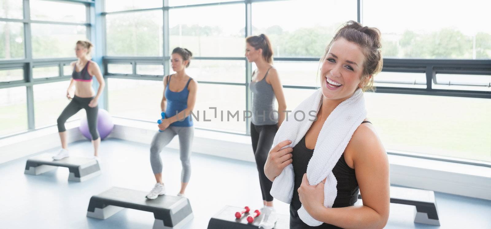 Happy woman taking a break at aerobics class by Wavebreakmedia