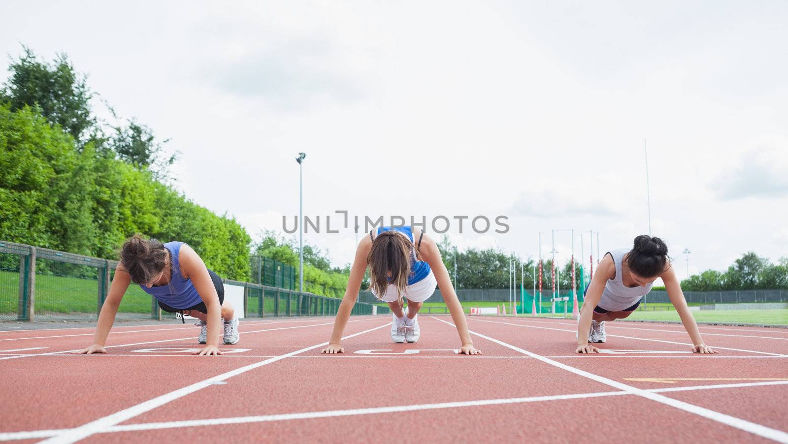 Three woman stretching on running track by Wavebreakmedia