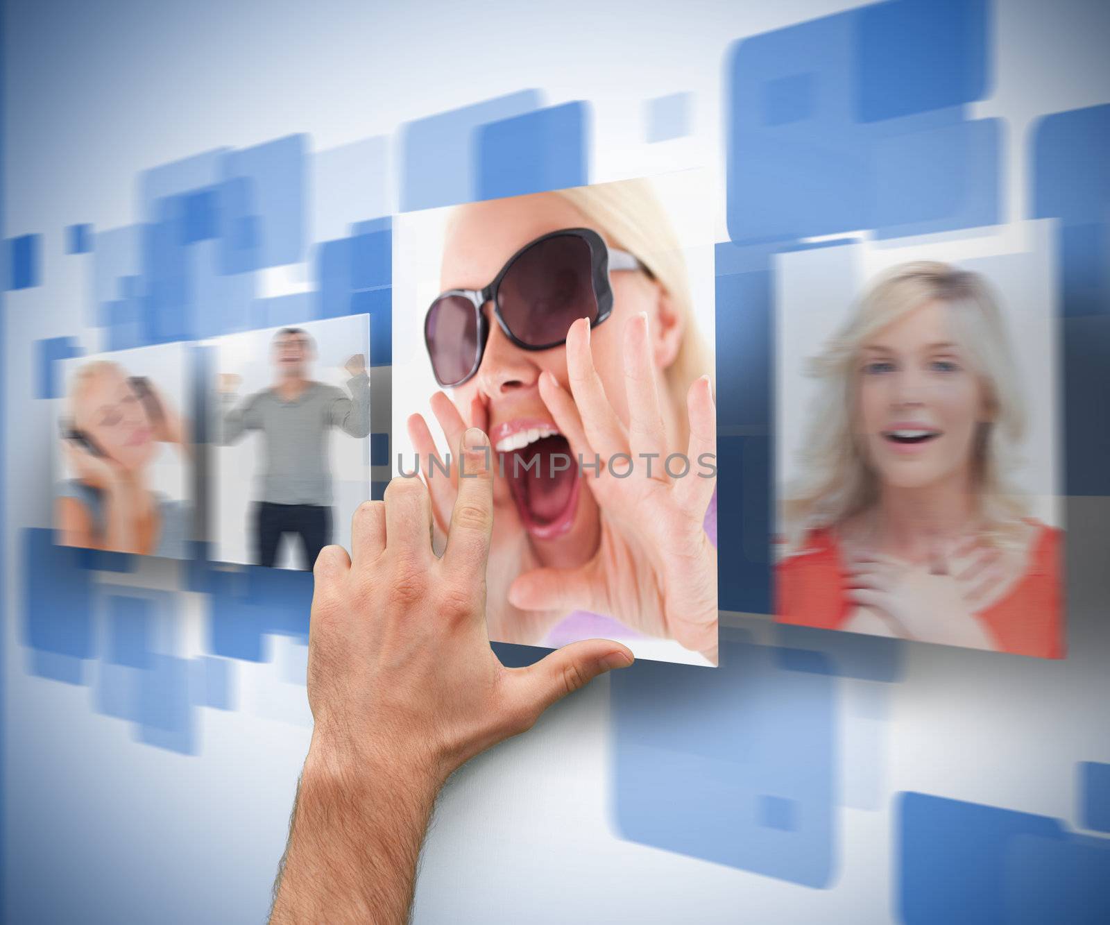 Male hand selecting picture from digital blue wall