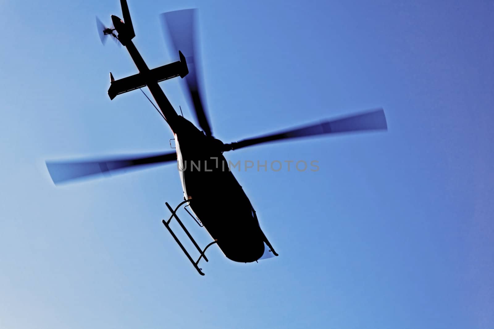 Generic silhouette of an helicopter caught  in flight against a clear blue sky. Actual location was Kashmir India but could have been taken anywhere on the globe