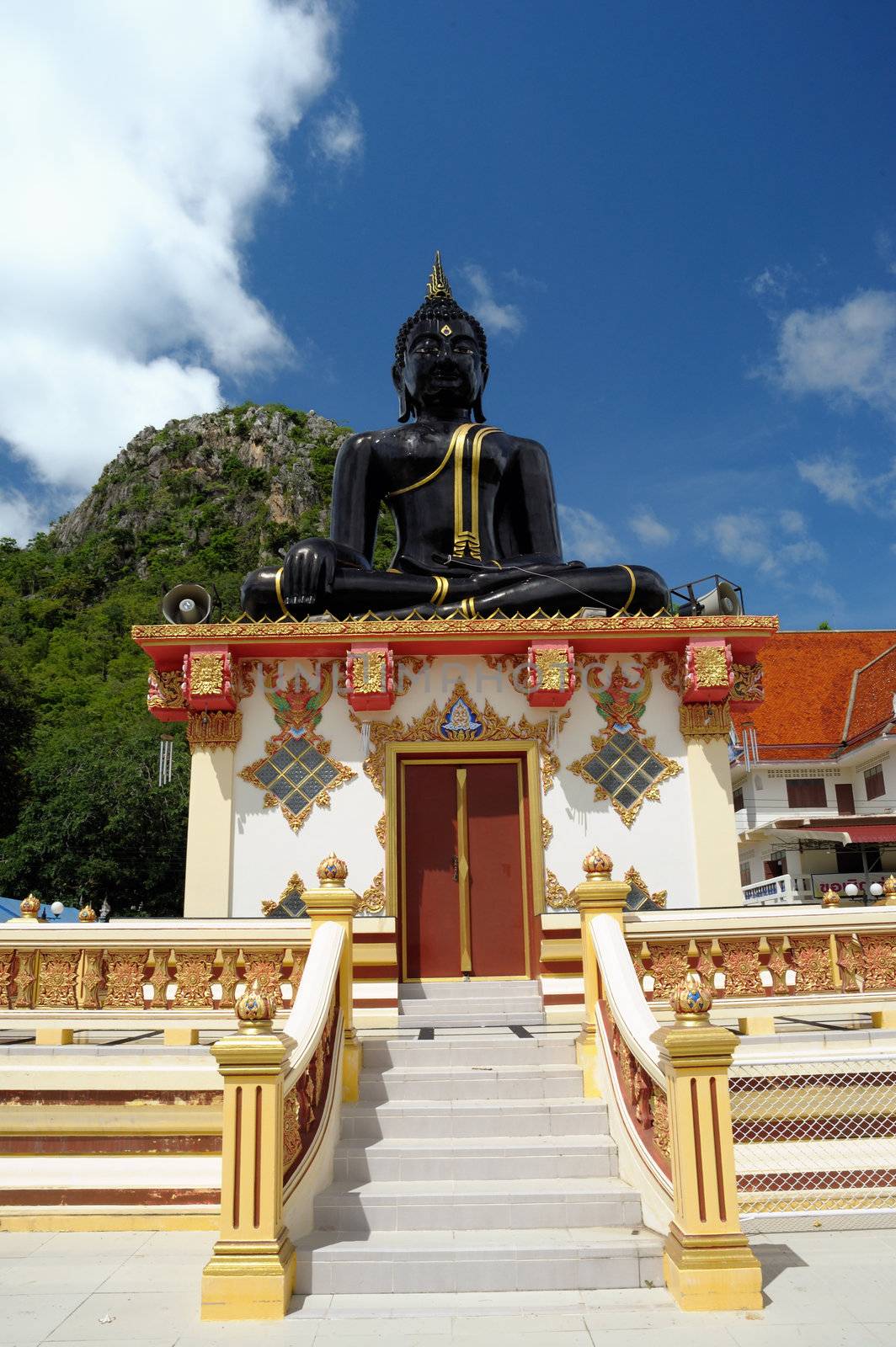 Big sacred black Buddha in sunny day.