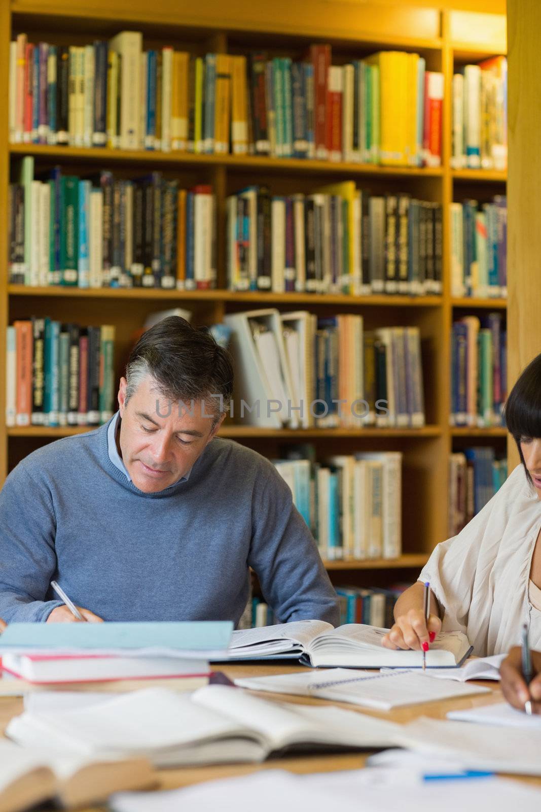 Man studying in library with others