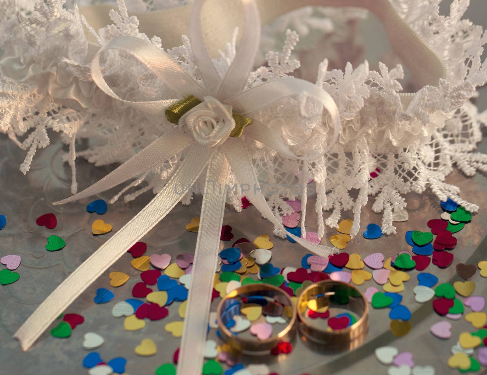 Two wedding rings on a background garters hearts scattered around