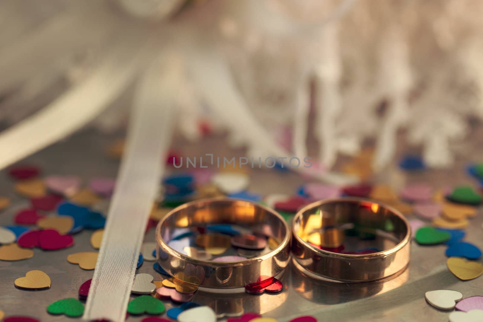 Two wedding rings on a background garters hearts scattered around