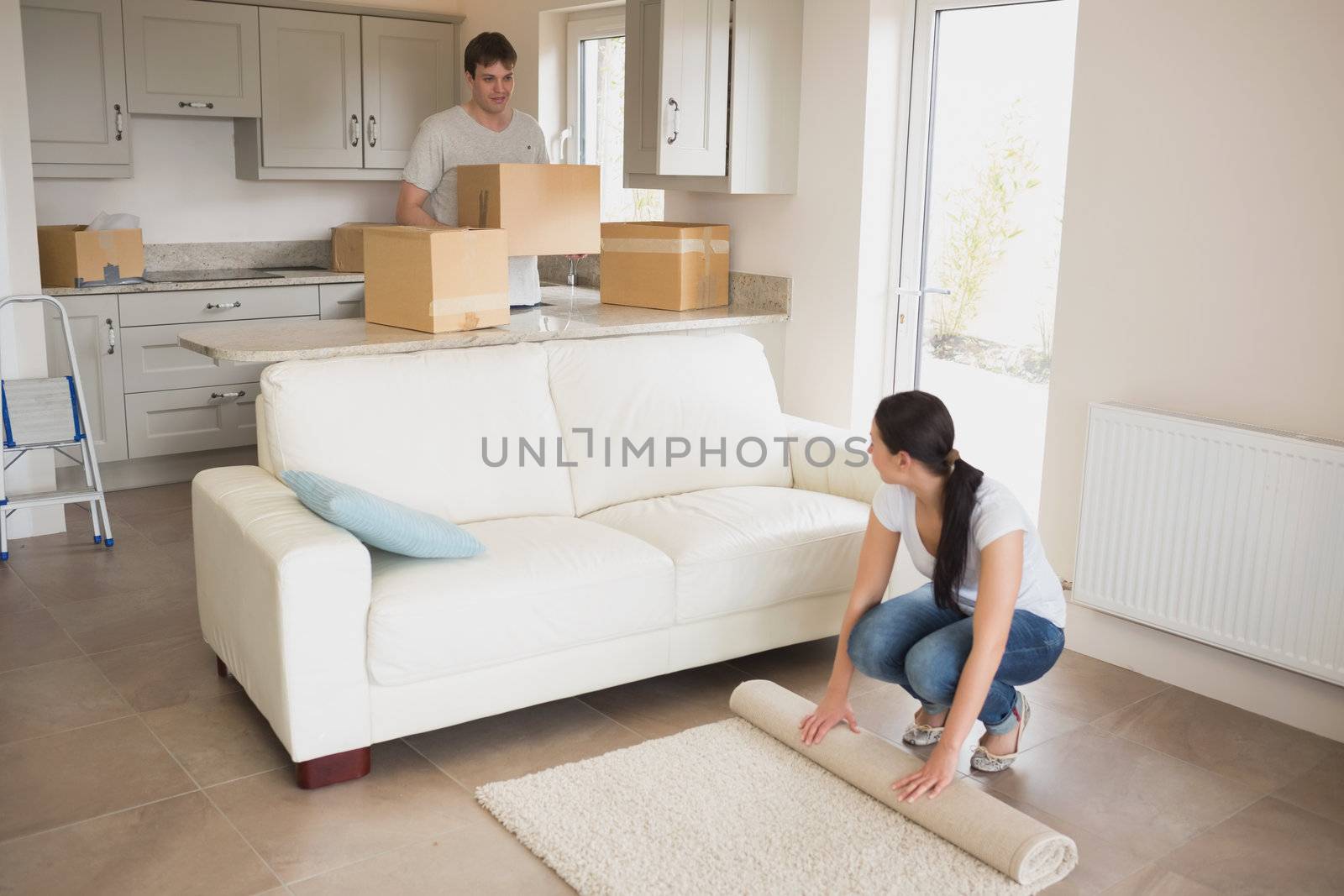 Two young people moving into their house and furnishing the living room