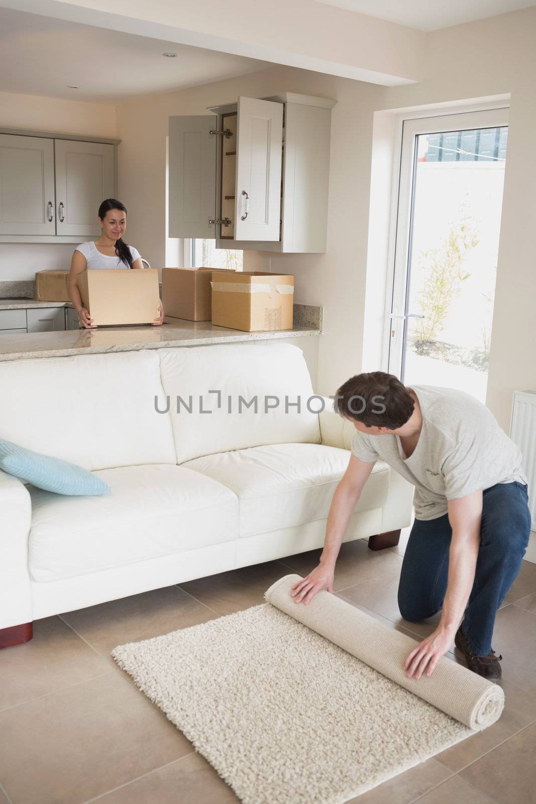 Two young people furnishing the kitchen and living room for a relocation