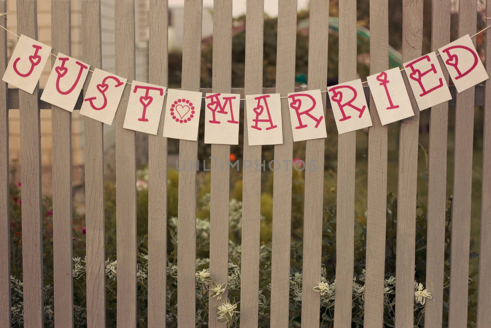 A sign on a white fence "JUST married"
