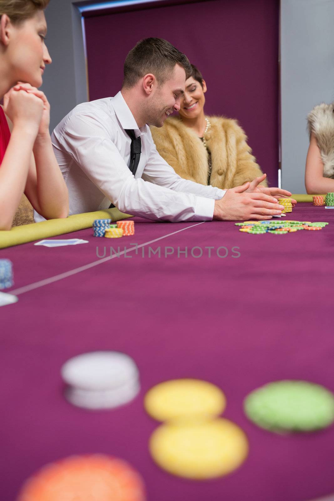 Happy people placing bets at poker game by Wavebreakmedia