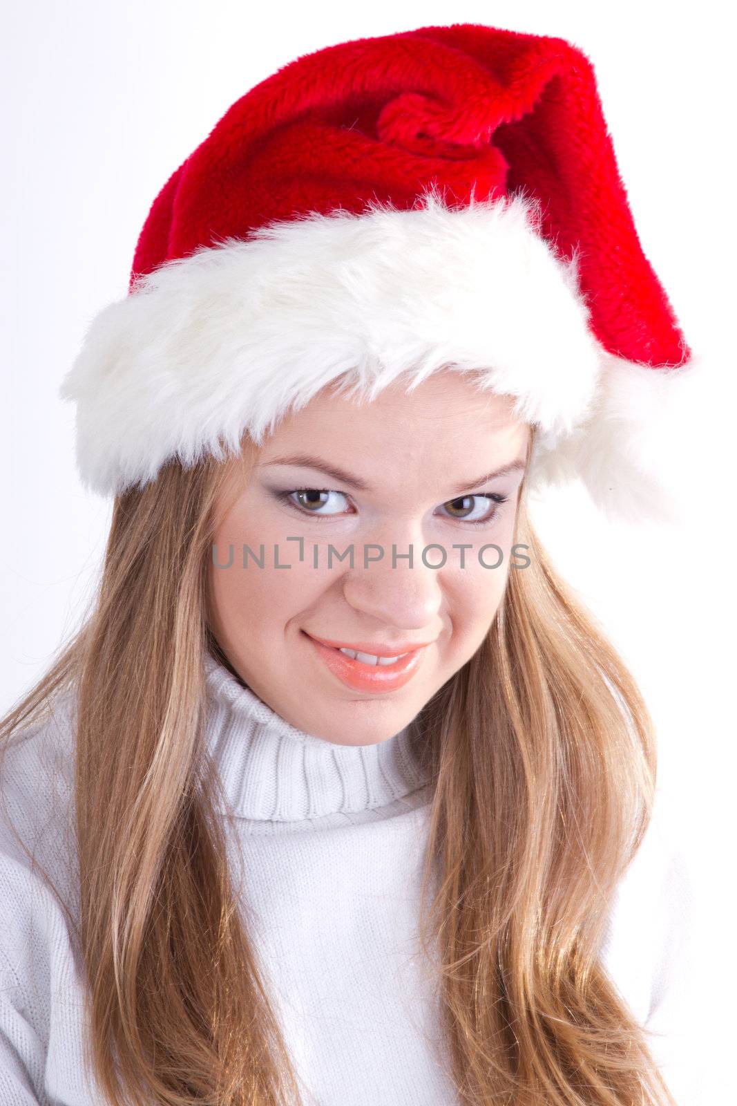 Beautiful girl in a Christmas hat on a light background