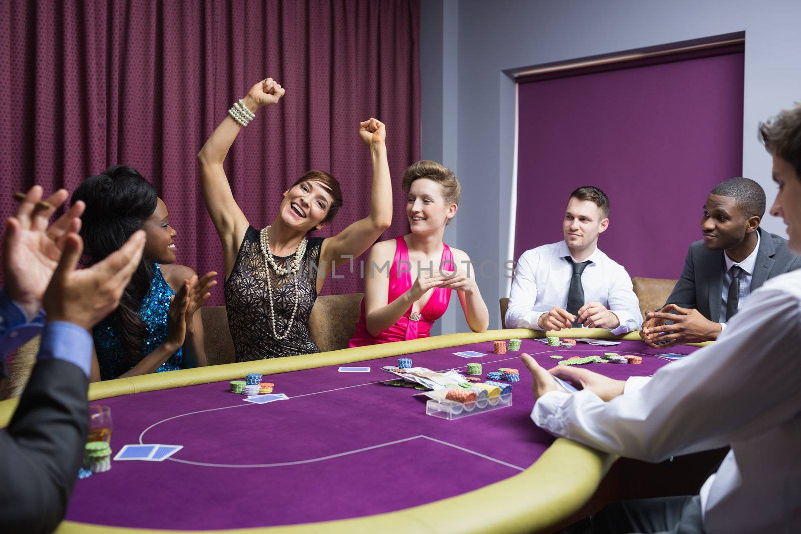 People cheering at poker table by Wavebreakmedia