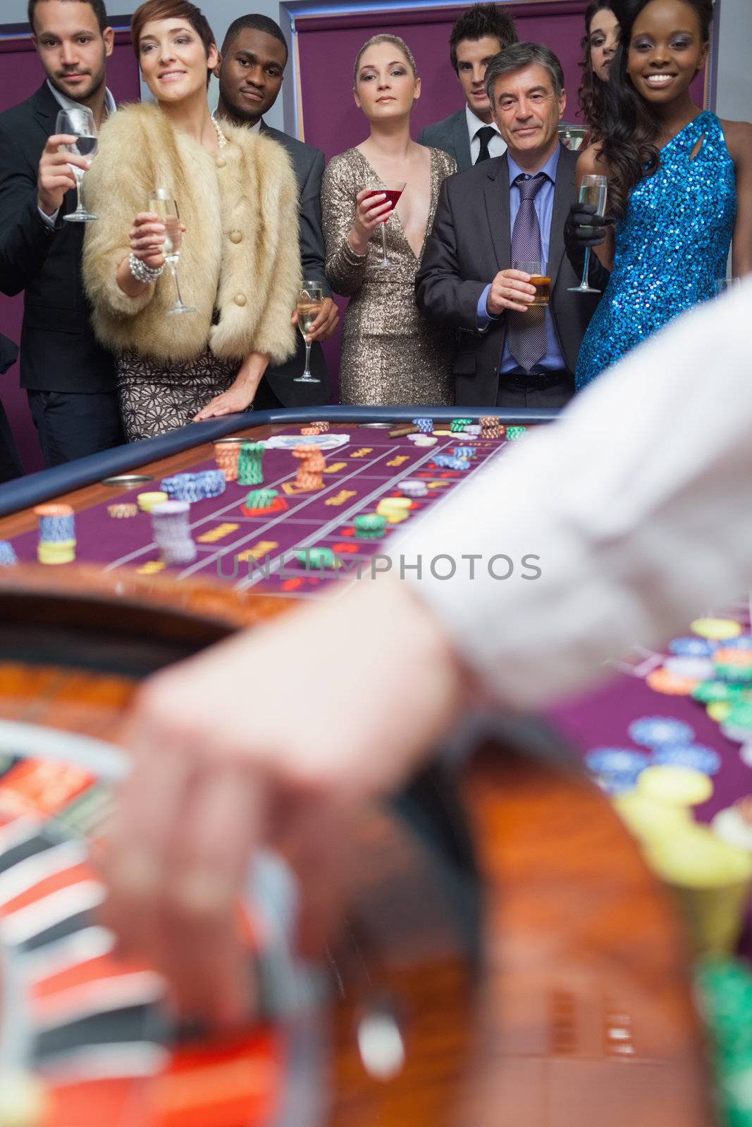 People looking at the roulette wheel by Wavebreakmedia