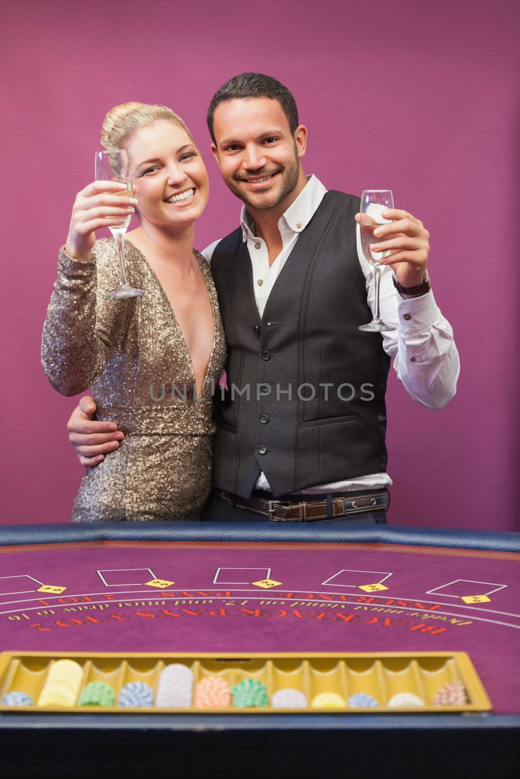 Two people toasting in a casino by Wavebreakmedia