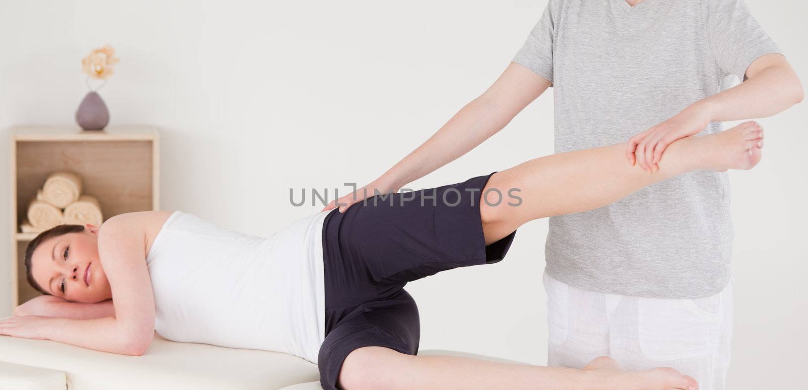 Sportswoman having a leg and hips stretching by Wavebreakmedia