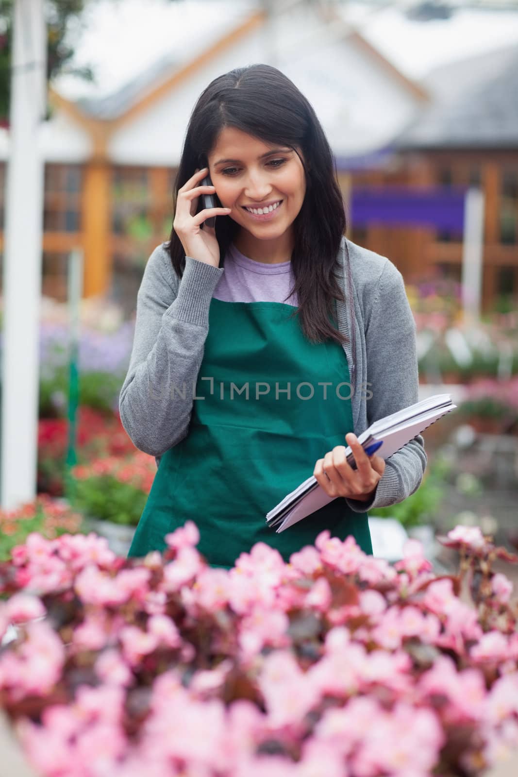 Black-haired woman calling while doing stocktaking by Wavebreakmedia