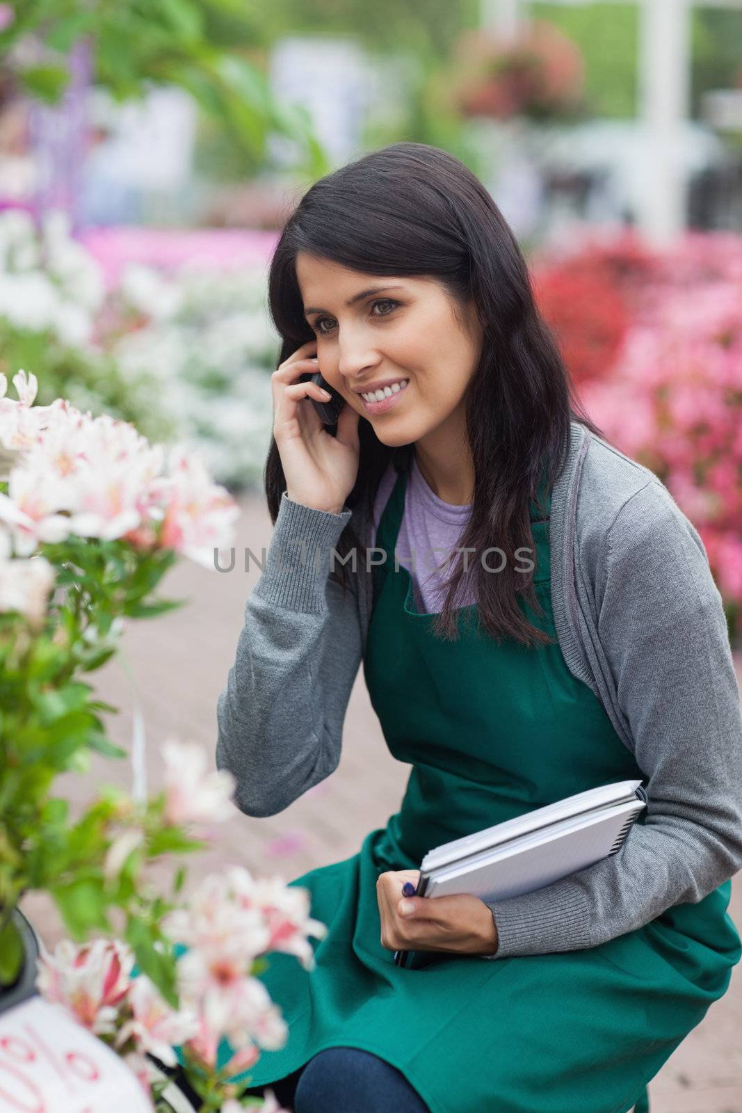 Employee doing stocktaking while calling in garden center by Wavebreakmedia