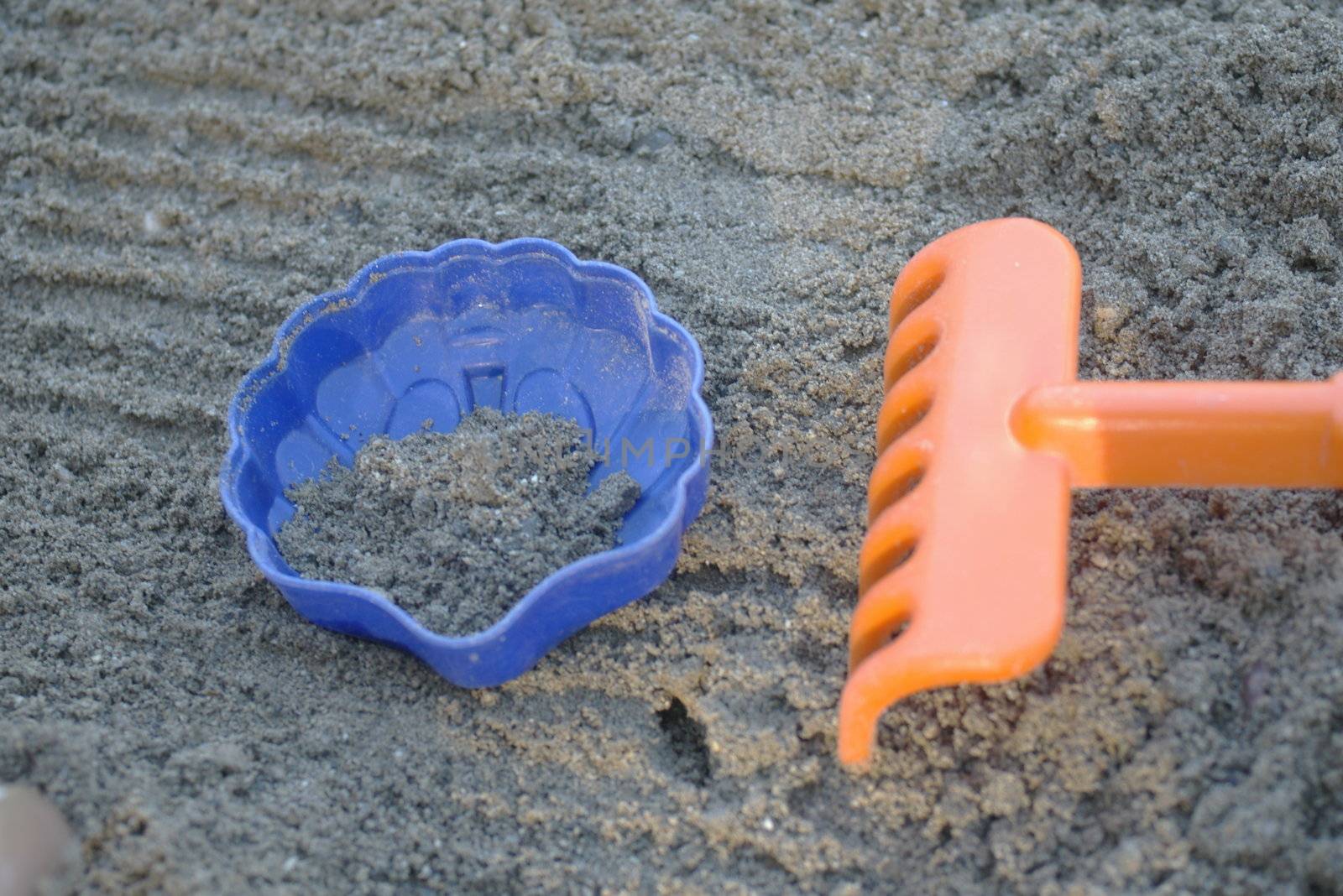 colorful plastic toys in a sandbox colorful plastic toys in a sandbox