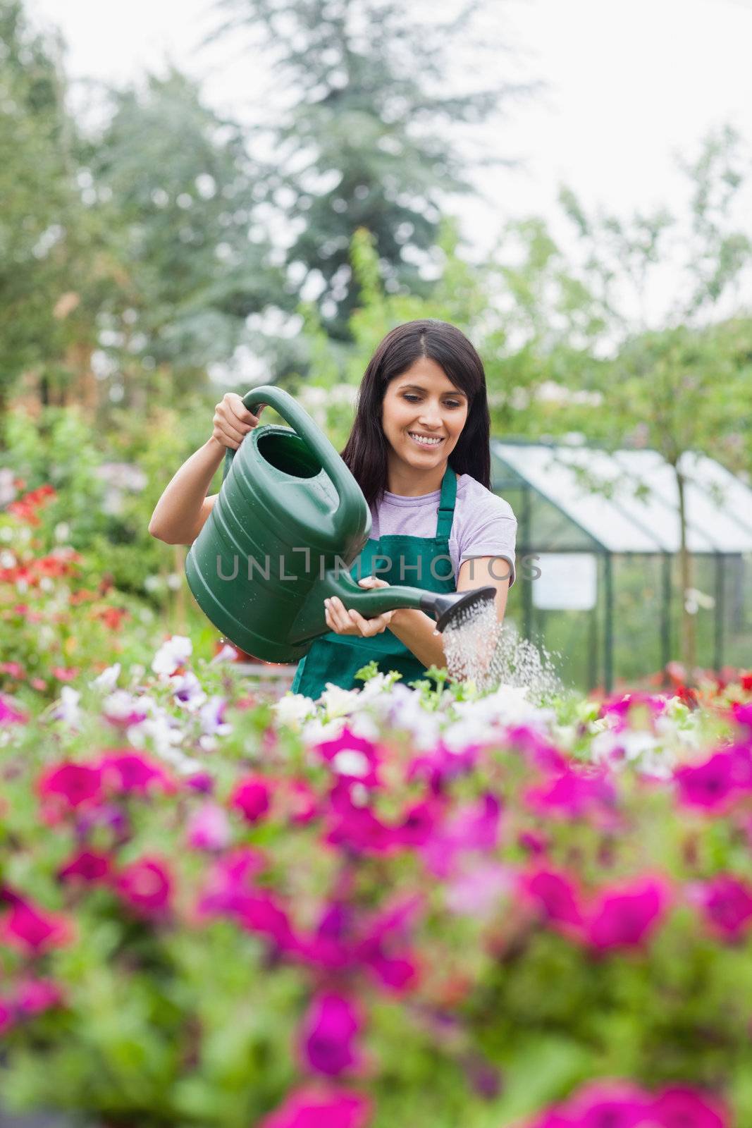 Assistant watering flowers by Wavebreakmedia