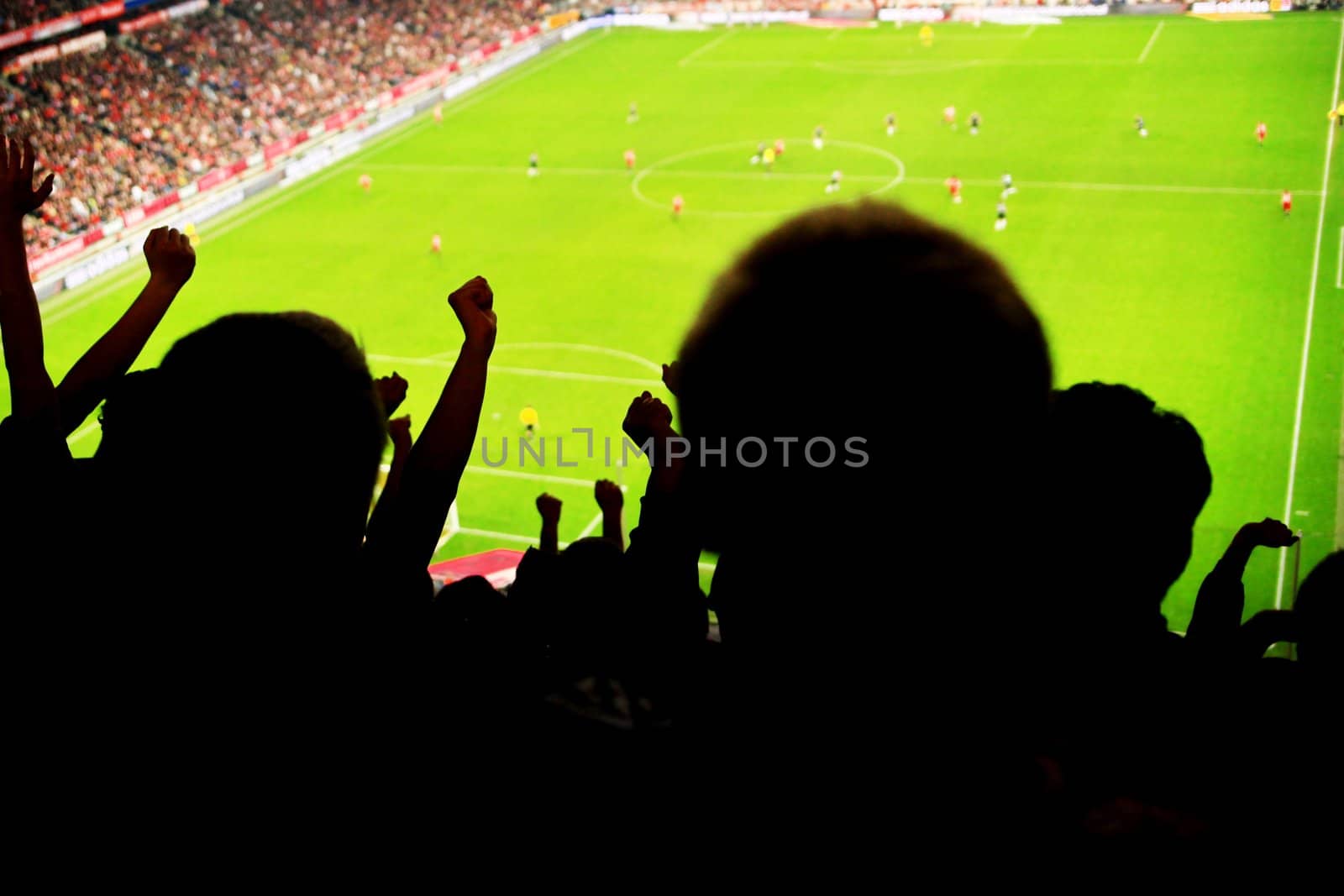 Silhouettes of fans celebrating a goal on football match