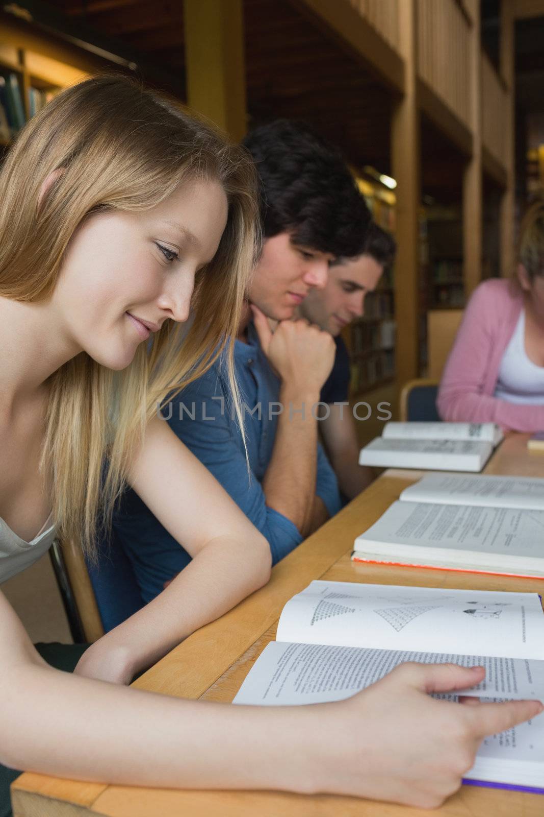 Students studying around library table in college library