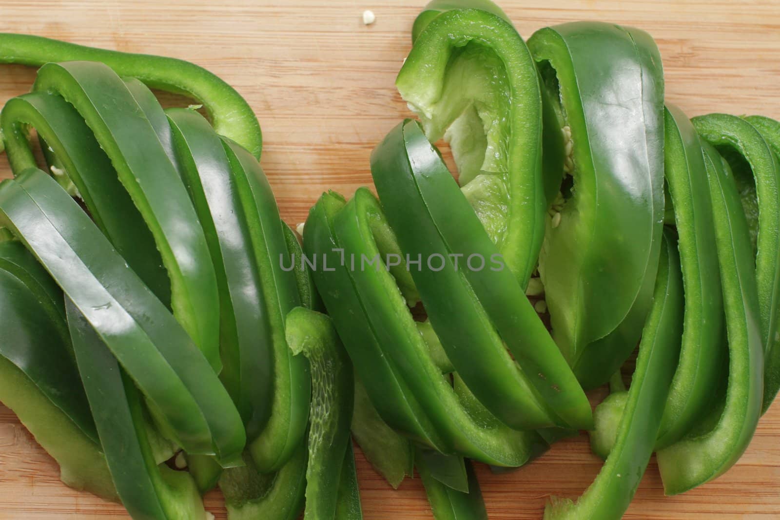 many pepper slices on a wooden background