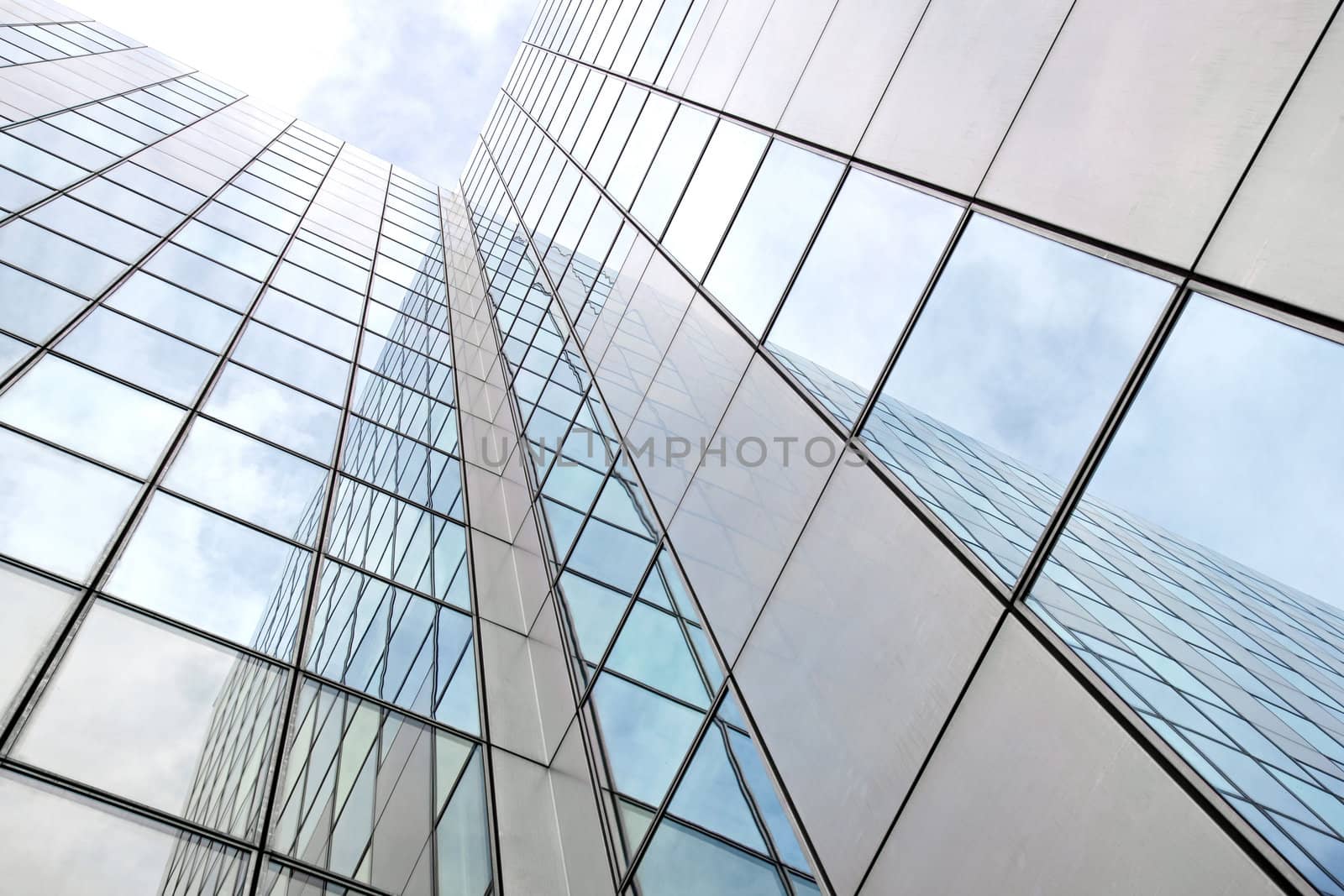 modern facade of glass and steel reflecting clouds