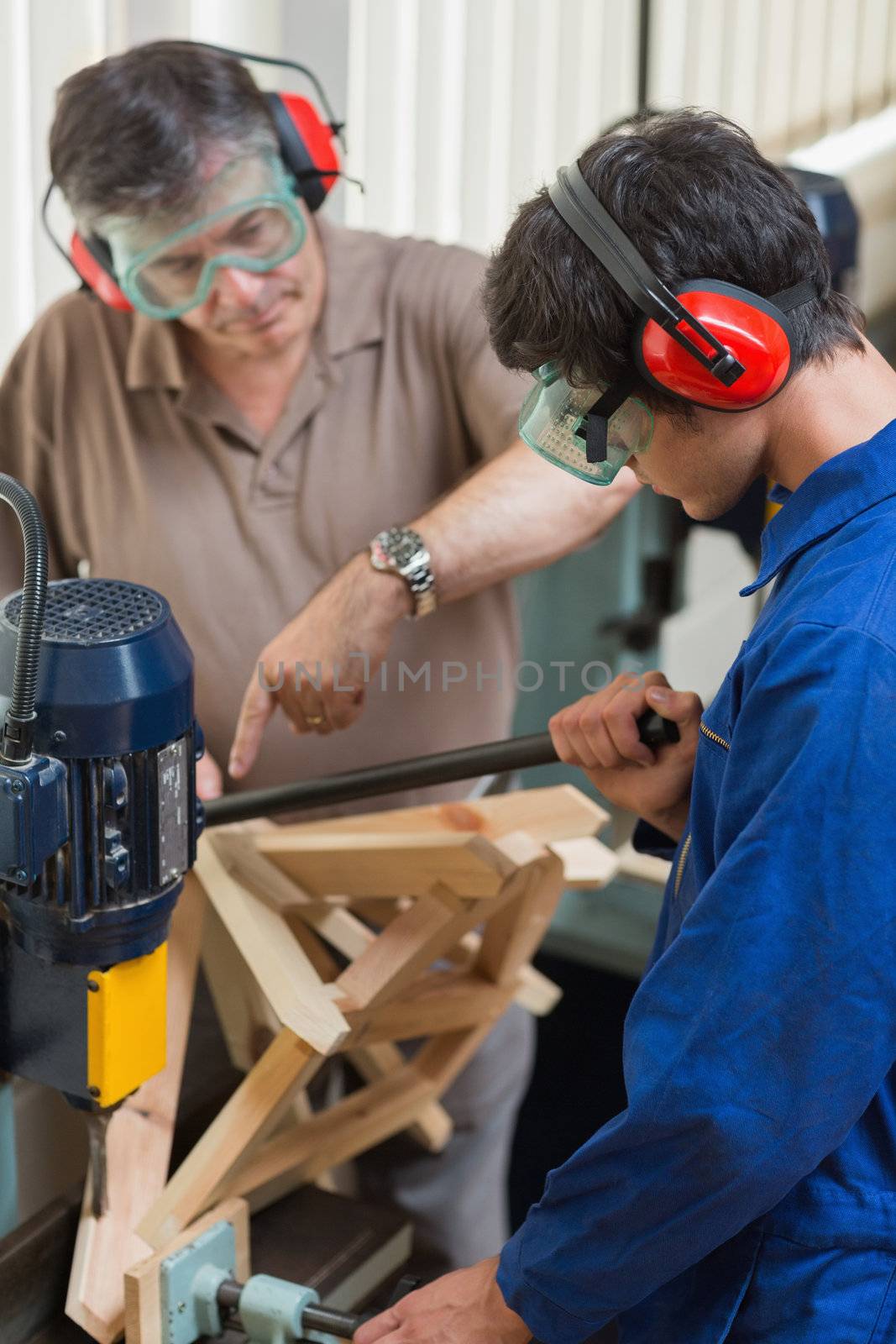 Man standing at a drilling machine working 