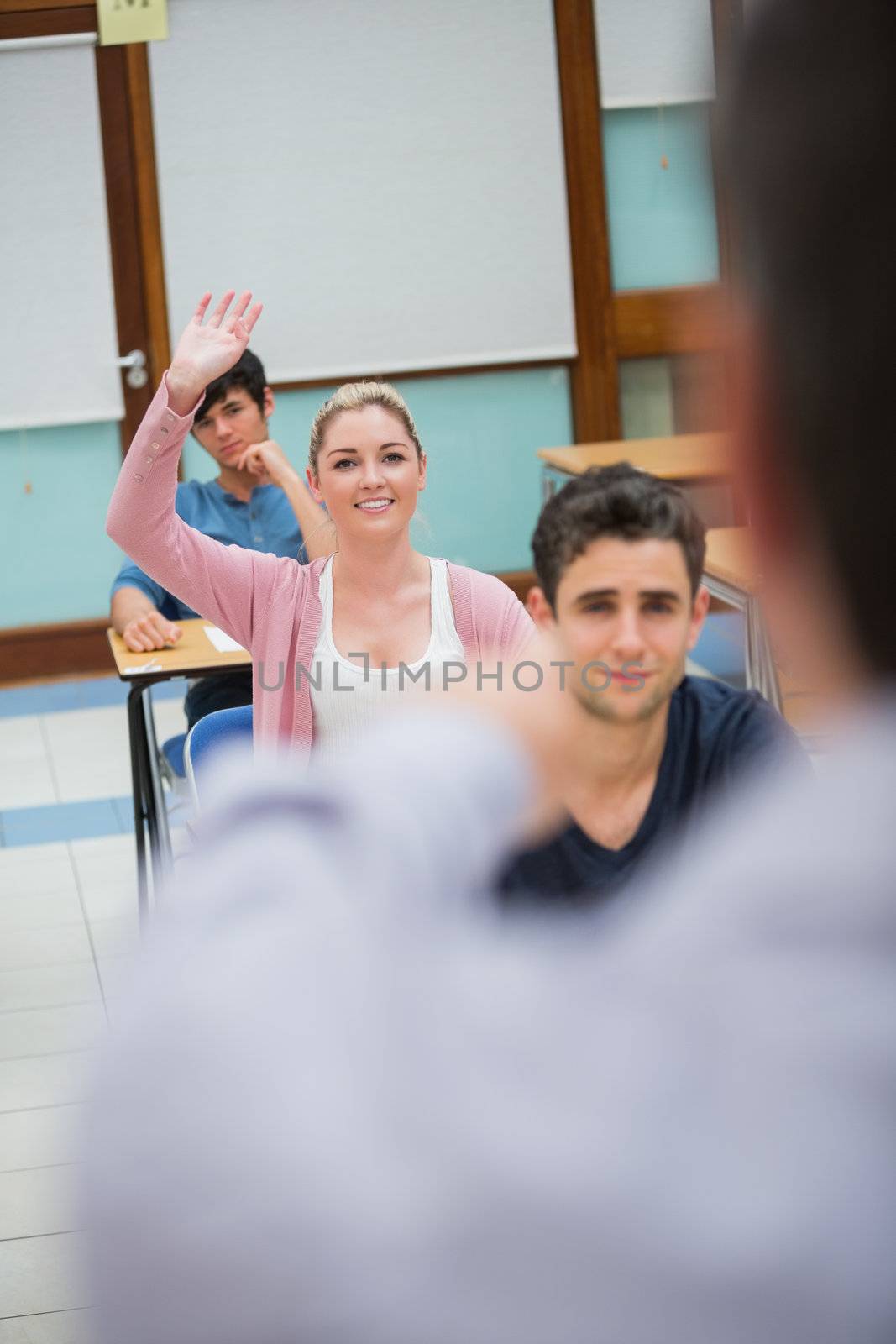 Woman asking question in classroom in college