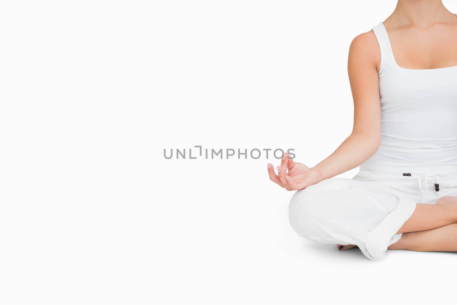 Woman doing yoga while cross-legged  by Wavebreakmedia