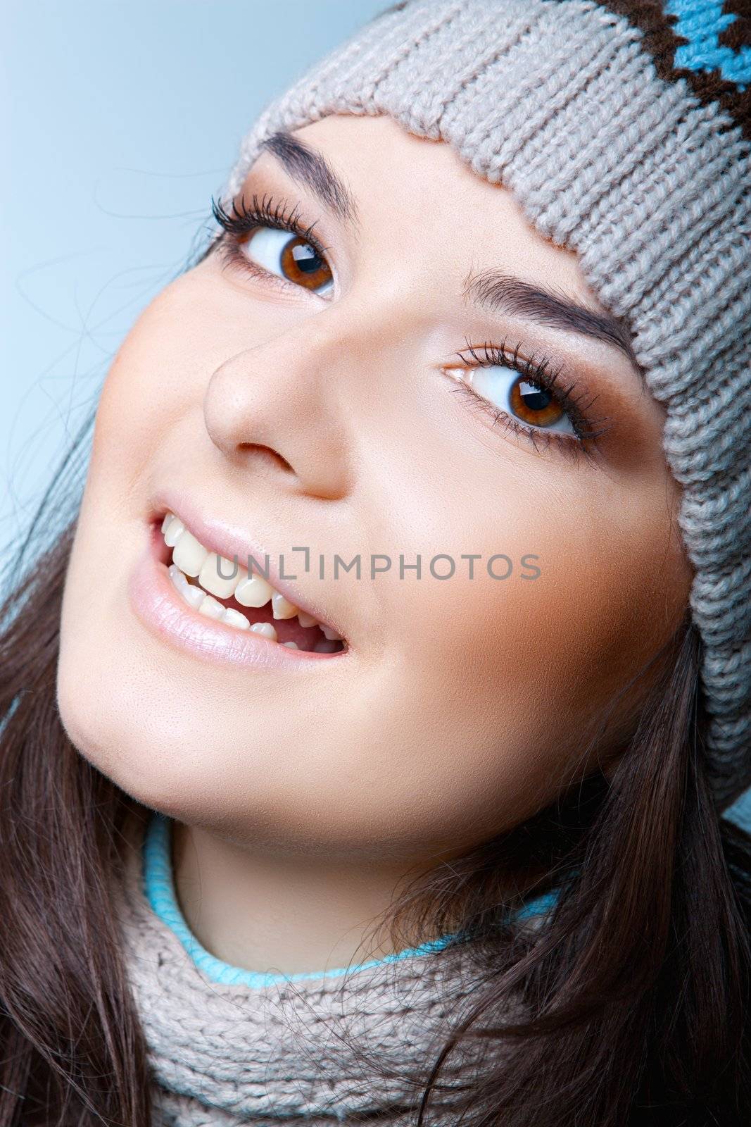 Smiling woman in a cap on the blue background