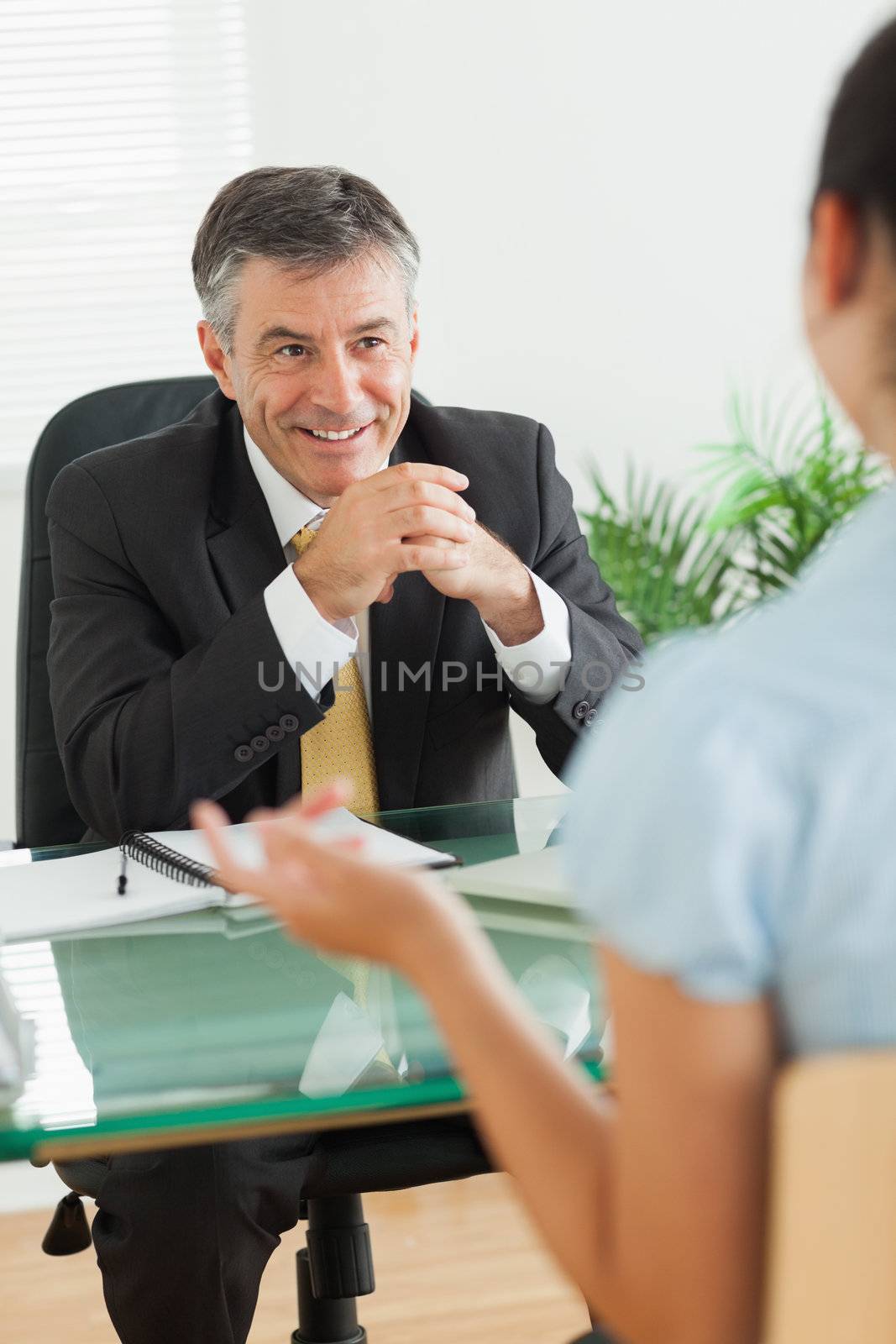 Businessman laughing with a woman in his office by Wavebreakmedia