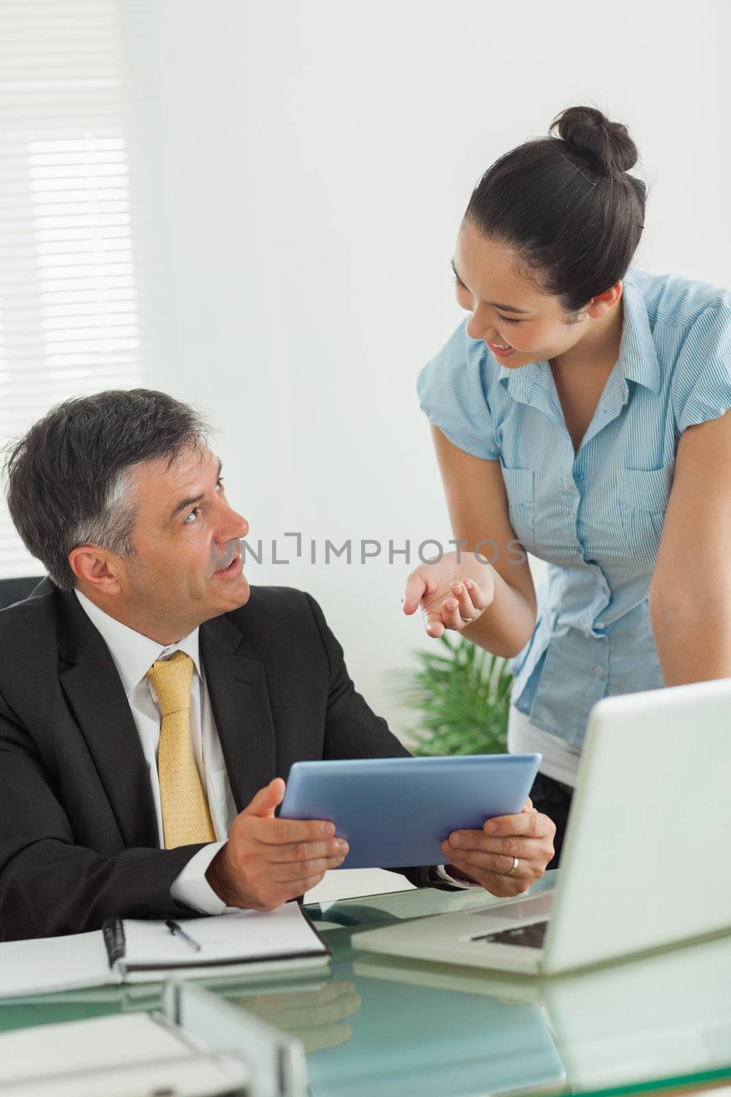 Business people working on the same digital tablet in an office