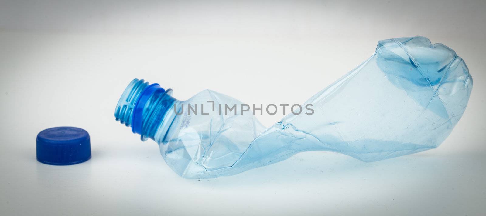 Empty plastic bottle crushed and blue cap for recycling