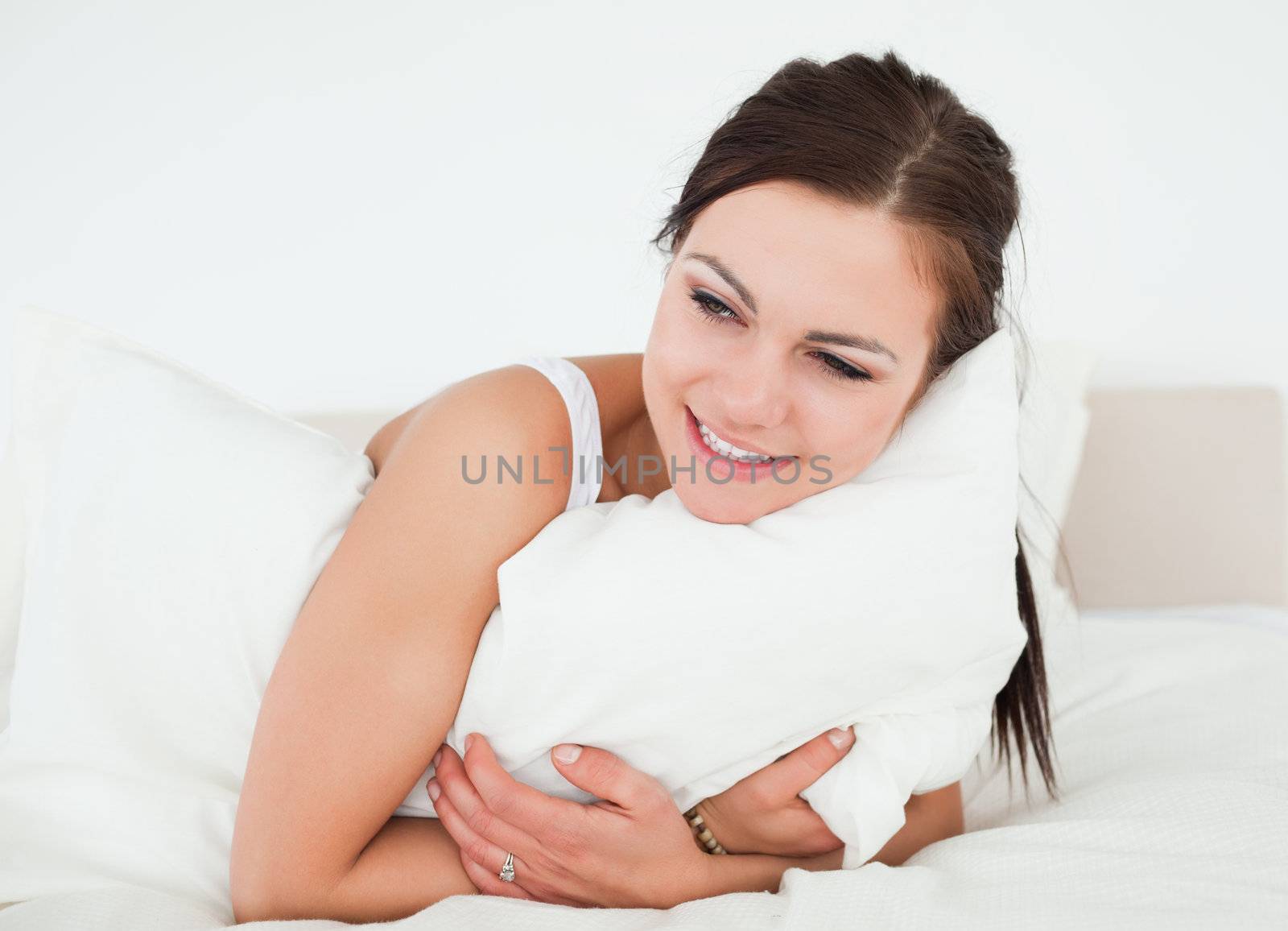 Young woman holding a pillow by Wavebreakmedia