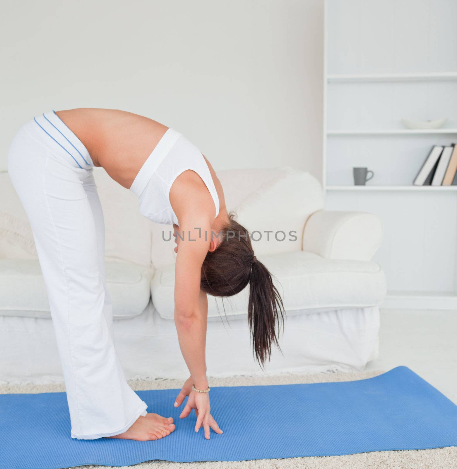 Cute brunette practicing yoga in her living room