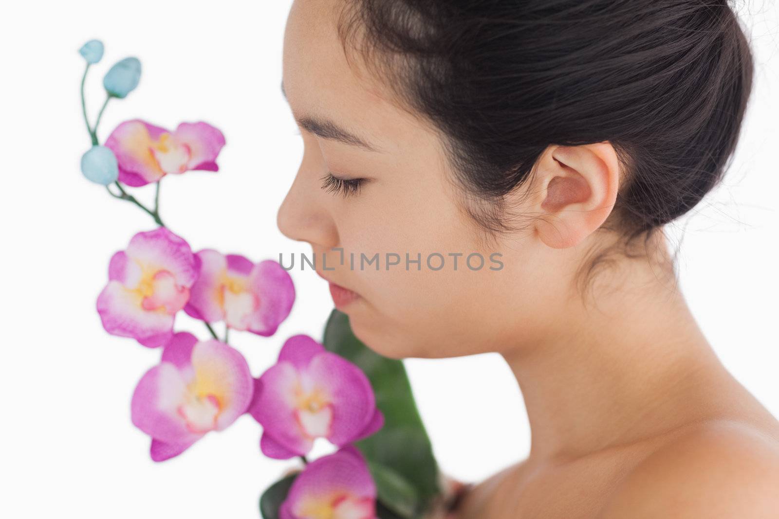 Woman smelling on orchids by Wavebreakmedia
